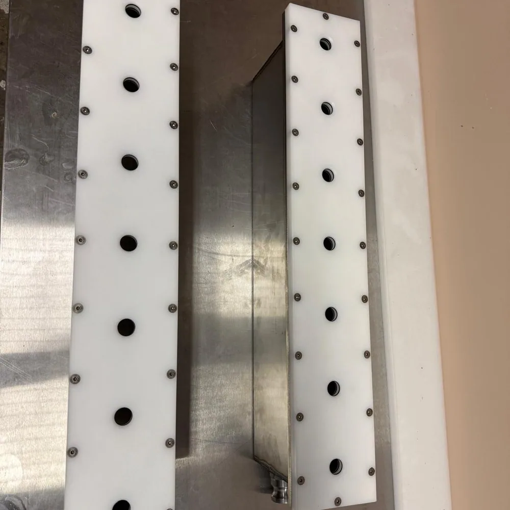 Vue de dessus des deux rampes en polymère technique : perçages alignés et vissage inox fraisé — Alésage XC